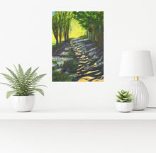 Load image into Gallery viewer, A tree lined path showing the sun peeping through the trees, leaving a shadowy light on the ground.  Bright sunlight and crop filled trees can be seen in distance.  Room mock-up with painting on a white shelf with plants