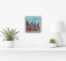 Load image into Gallery viewer, Image show Wonderous painting in a wooden box frame in a white wall over a shelf with potted plants. 