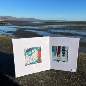 two denim abstract  mini paintings sitting on sea wall in Blackrock