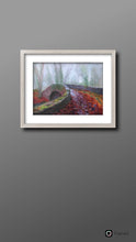 Load image into Gallery viewer, Room setting with silver white frame on wall with the Oldbridge canal bridge in foreground with fallen autumn leaves on ground.  Bare ivy covered trees in background.  art for sale  gift ideas