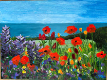 Load image into Gallery viewer, Red poppies and purple lupins in the foreground with a green lawn and hedgerow behind.  The blue sea in the distance below a light blue summery sky.  Seaside floral acrylic painting.  art for sale and gift ideas  Ireland