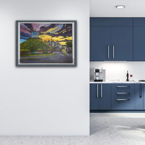 light wood frame on the Millmount Tower sunrise painting in the Room Setting image of a blue kitchen